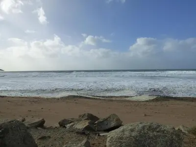 a beach with rocks and the ocean on a cloudy day at Shepherds Retreat in Launceston
