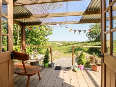 a wooden pergola with a table and a chair on a deck at Shepherds Retreat in Launceston