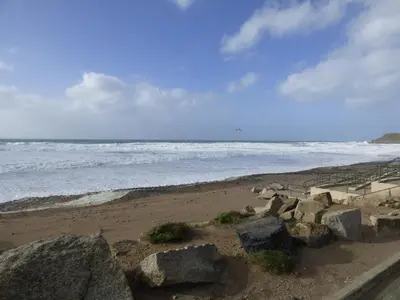 a beach with some rocks and the ocean at Puddle Duck Shepherds Hut in Launceston