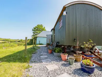 a barn with potted plants on the side of it at Puddle Duck Shepherds Hut in Launceston
