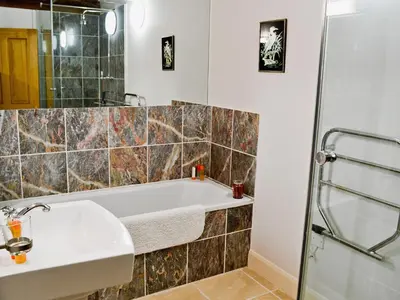 a bathroom with a tub and a sink and a shower at Penno Cottage - 24440 in Bodmin