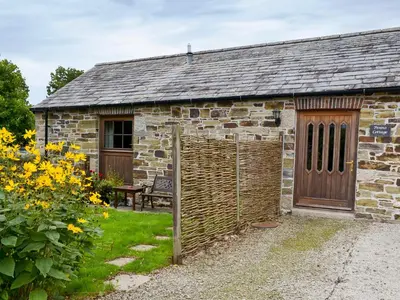 an old stone building with a wooden door at Penno Cottage - 24440 in Bodmin