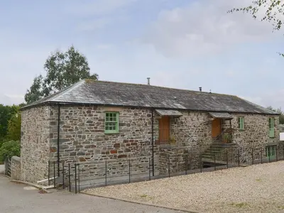 an old stone building with a fence around it at The Coach House - 24439 in Bodmin
