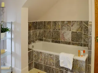a bathroom with a bath tub in a room at The Coach House - 24439 in Bodmin