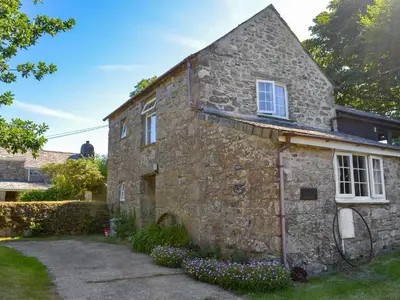 an old stone house in a yard at Wallhouse Barn in Blisland