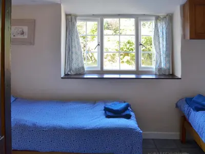 a bedroom with two beds and a window at Wallhouse Barn in Blisland