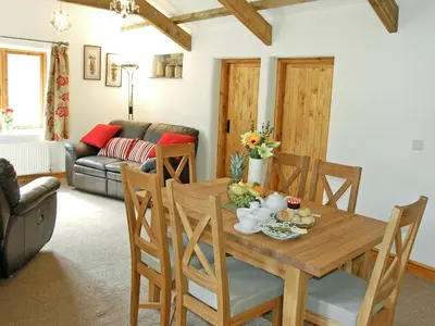 a living room with a wooden table and chairs at The Stables in Bodmin