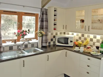 a kitchen with a sink and a microwave at The Stables in Bodmin