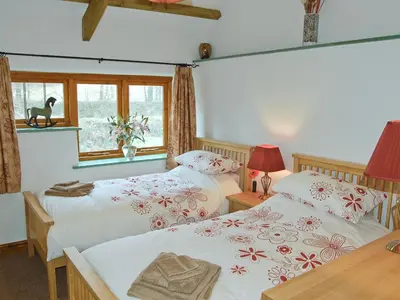 a bedroom with two beds and a window at The Stables in Bodmin