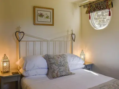 a bedroom with a bed and two lamps and a window at The Old Chapel in Washaway