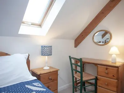 a bedroom with a bed and a desk and a mirror at The Roundhouse - Tbe in Crackington Haven