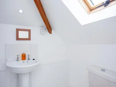a white bathroom with a sink and a toilet at The Roundhouse - Tbe in Crackington Haven