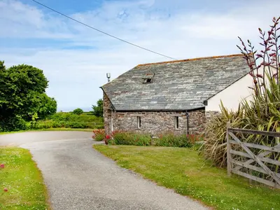 an old stone house with a gravel road at The Roundhouse - Tbe in Crackington Haven