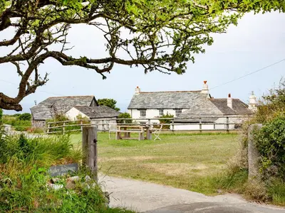 a farm house with a fence and a field at The Roundhouse - Tbe in Crackington Haven