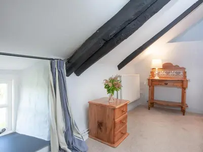 a attic room with a wooden dresser and a table at The Annexe - Tbh in Crackington Haven