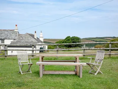 two chairs and a wooden bench in the grass at The Annexe - Tbh in Crackington Haven
