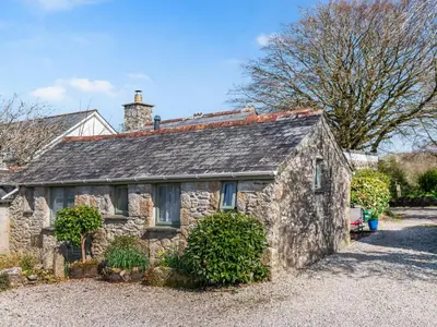a stone house with a roof on a driveway at Cross Cottage in Saint Breward