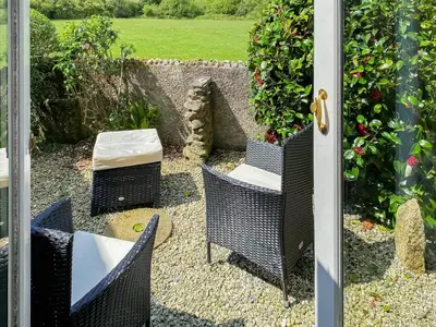 a door leading into a patio with chairs and a table at High View in Saint Breward