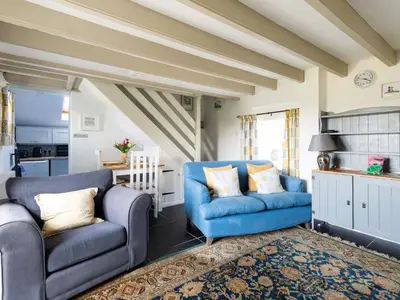 a living room with two blue chairs and a rug at High View in Saint Breward