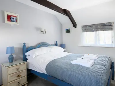 a bedroom with a blue and white bed and a window at High View in Saint Breward