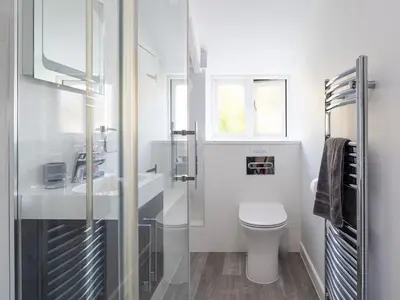 a white bathroom with a toilet and a sink at High View in Saint Breward