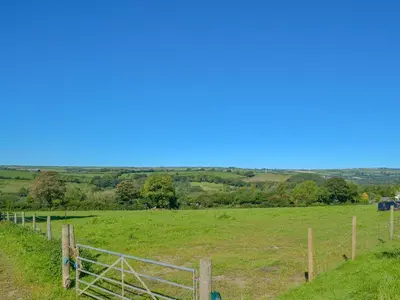 a fence in the middle of a field at Campion Cottage in Saint Teath