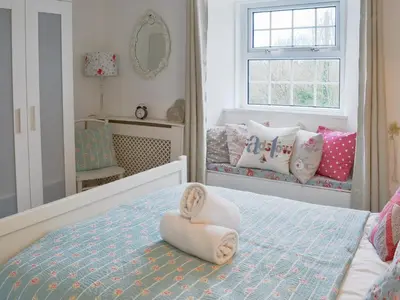 a bedroom with a bed with towels on it at Gumburnville in Lanteglos