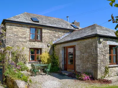 an old stone house with a table and a patio at Well Barn in Lanteglos