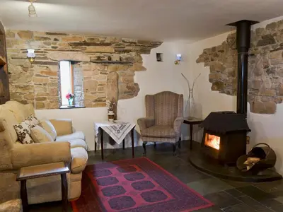 a living room with a couch and a fireplace at Well Barn in Lanteglos