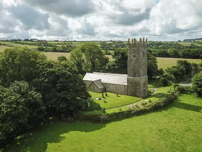 an aerial view of an old church in a field at Drovers in Lanteglos