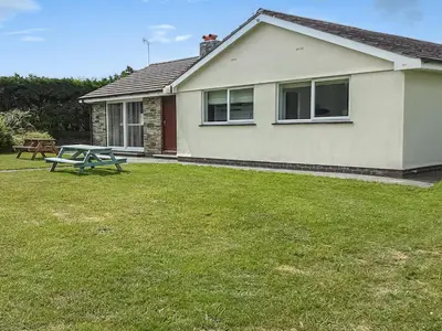 a house with a picnic table in the yard at Valley Truckle Bungalow in Camelford