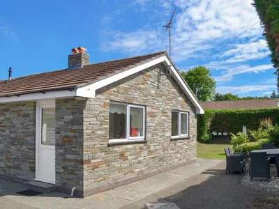 a brick house with a white door and windows at Valley Truckle Bungalow in Camelford