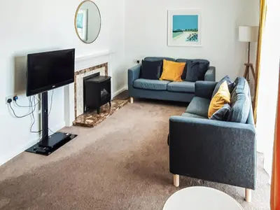 a living room with two blue couches and a tv at Valley Truckle Bungalow in Camelford
