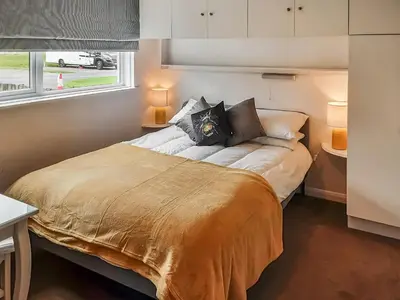 a bedroom with a large bed with a window at Valley Truckle Bungalow in Camelford