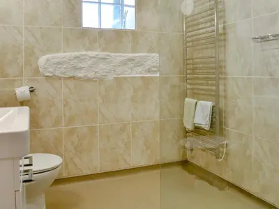 a bathroom with a toilet and a shower with towels at Dovecote-Tnq in Camelford