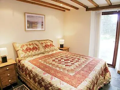 a bedroom with a large bed and a window at The Stable in North Petherwin