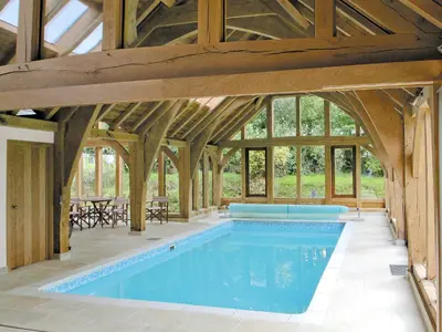 an indoor pool in a barn with wooden beams at Barfield's Cherry Tree Cottage in Warbstow