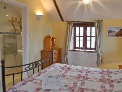 a bedroom with a bed and a window at Barfield's Cherry Tree Cottage in Warbstow