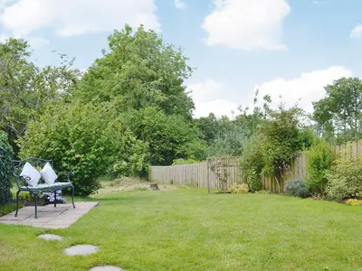 a garden with a bench in the grass at Barton Cottage in North Petherwin