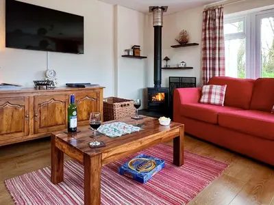 a living room with a red couch and a table at Blackberry Cottage in North Hill