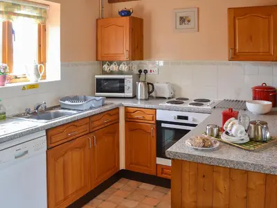 a kitchen with a sink and a stove top oven at Merlin View in Saint Mawgan