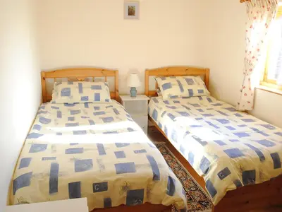 two beds sitting next to each other in a bedroom at Merlin View in Saint Mawgan