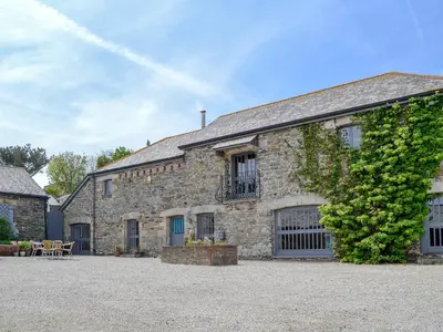 an old stone building with a table and chairs at Trescowthick Barn in Zelah