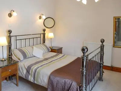 a bedroom with a bed and a desk and a mirror at Trescowthick Barn in Zelah