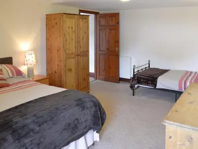 a bedroom with two beds and a dresser at Trescowthick Barn in Zelah