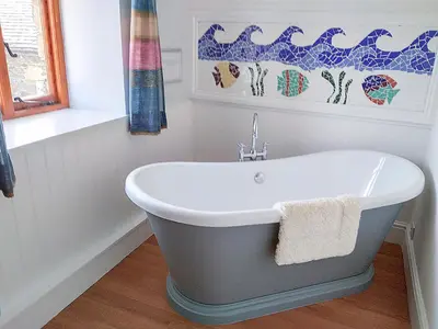 a bath tub in a bathroom with a sink at Trescowthick Barn in Zelah