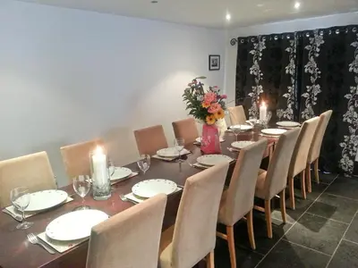 a dining room with a long table with chairs and candles at Trescowthick Barn in Zelah