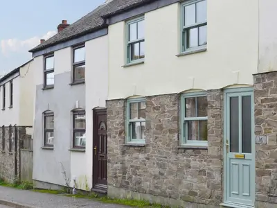 an old stone house with blue windows at Willow Cottage in Newlyn East