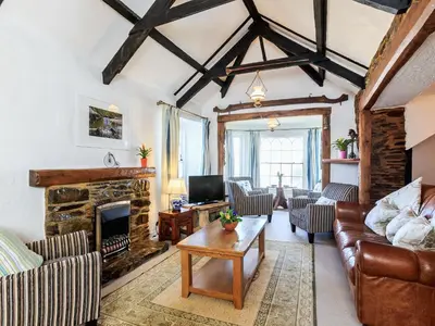 a living room with a couch and a fireplace at Manor House in Crantock