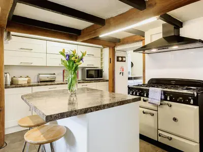 a kitchen with a vase of flowers on a counter at Manor House in Crantock